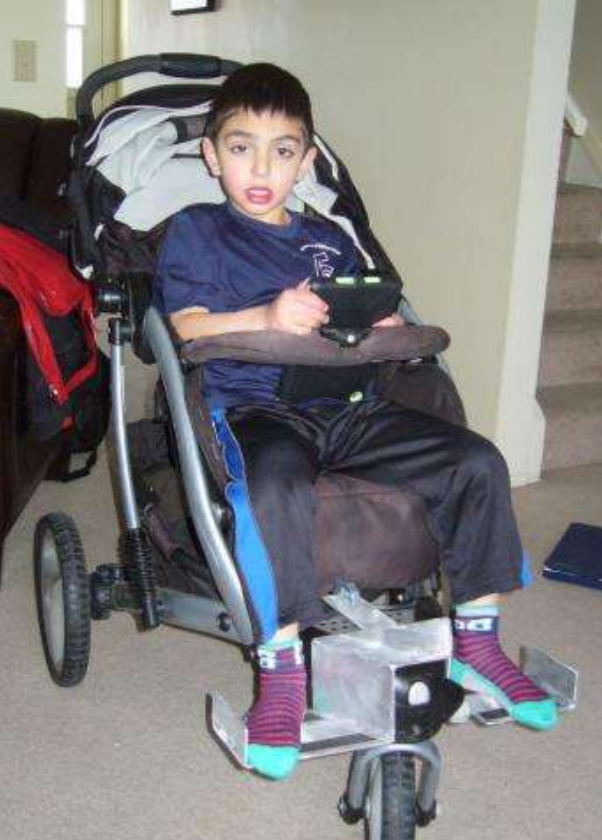 Young boy sitting in a stroller playing on an ipad